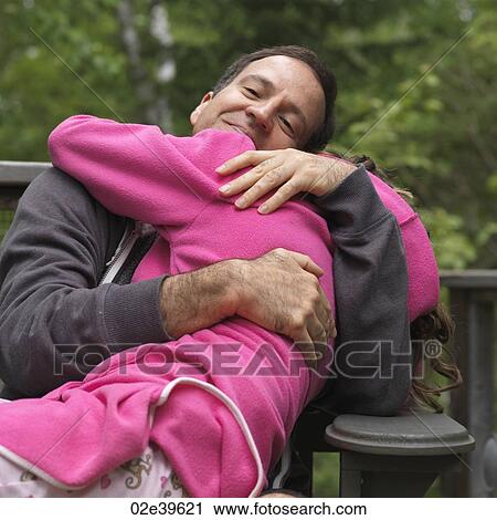 Stock Image - Young girl hugging her Father at Lake of the Woods, Ontario. Fotosearch