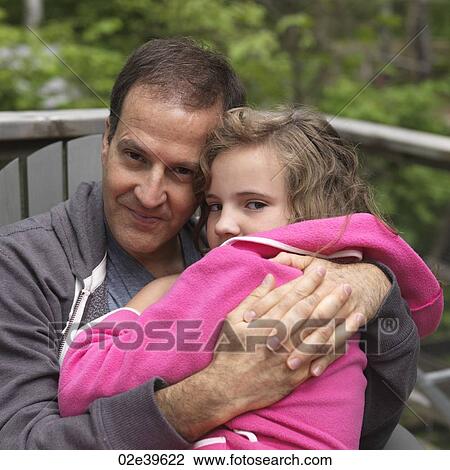 Stock Image - Young girl hugging her Father at Lake of the Woods, Ontario. Fotosearch