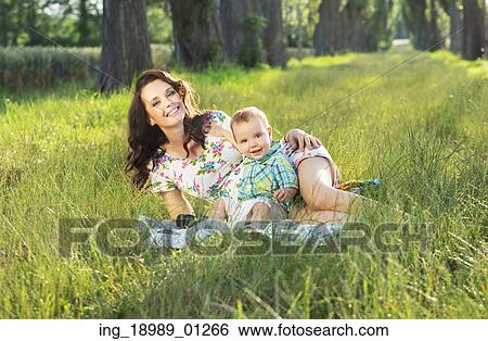 Stock Photograph - Adorable mom realxing with her cute baby son. Fotosearch