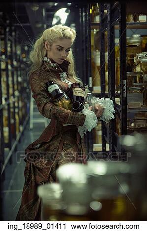 Stock Image - Alluring chemist holding huge jars with medicines. Fotosearch