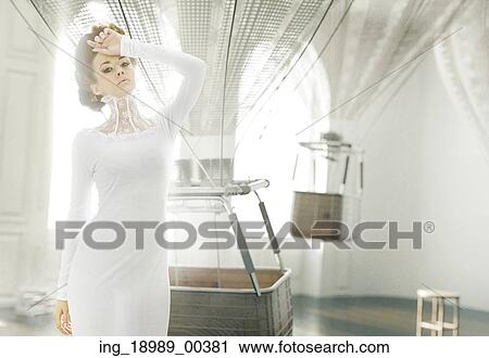 Stock Image - Alluring lady in the room full of dirigible balloons. Fotosearch