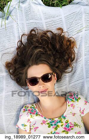 Stock Photo - Alluring woman lying on the blue blanket. Fotosearch