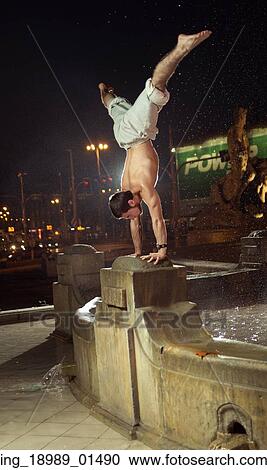 Amazing man doing sport figures in the fountain View Large Photo Image Stock Image - Amazing man doing sport figures in the fountain. Fotosearch
