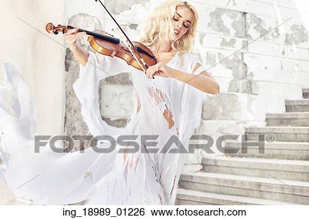 Stock Photograph - Amazing portrait of the pretty female musician. Fotosearch