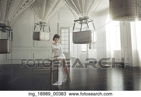 Stock Image - Attractive brunette lady among balloons. Fotosearch