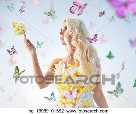 Stock Image - Attractive delicate woman playing with butterflies. Fotosearch