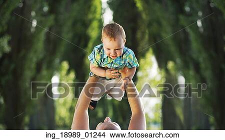 Picture - Attractive mom carrying her son. Fotosearch
