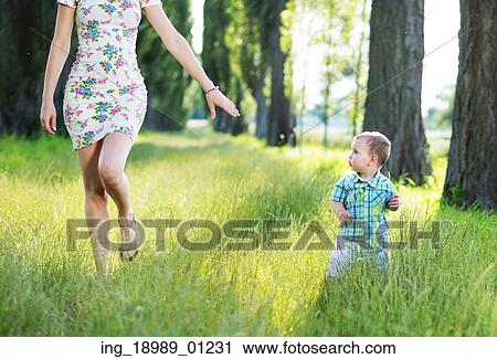 Beautiful mom playing in the park with her child View Large Photo Image Stock Image - Beautiful mom playing in the park with her child. Fotosearch
