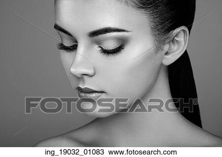 Stock Image - Beautiful woman face. Perfect makeup. Beauty fashion. Eyelashes. Cosmetic Eyeshadow. Highlighting. Black and white. Fotosearch
