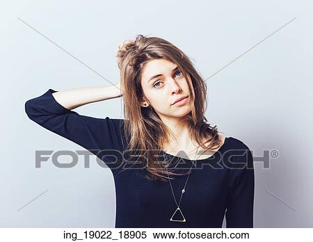 Stock Photography - Beautiful young business woman having a headache and holding her hands near head. Fotosearch