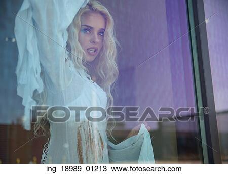 Stock Image - Blond lady behind the huge window. Fotosearch