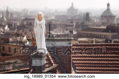 Blonde standing on the dirty chimney with the violin View Large Photo Image Picture - Blonde standing on the dirty chimney with the violin. Fotosearch