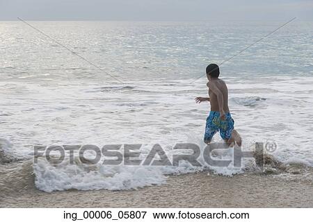 Boy running in waves on beach, Ixtapa, Guerrero, Mexico View Large Photo Image Stock Photo - Boy running in waves on beach, Ixtapa, Guerrero, Mexico. Fotosearch