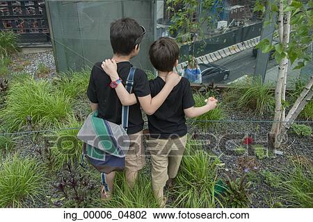 Stock Image - Boys looking at street from High Line Park, Chelsea, Manhattan, New York City, New York State, USA. Fotosearch
