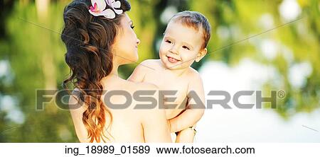 Brunette lady carrying her baby View Large Photo Image Stock Photo - Brunette lady carrying her baby. Fotosearch
