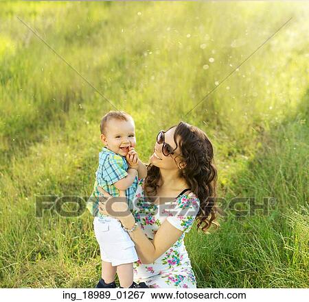 Stock Photo - Brunette mother carrying her lovely son. Fotosearch
