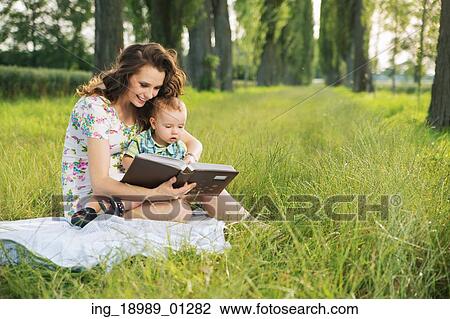 Stock Image - Brunette mother reading tales for her little child. Fotosearch