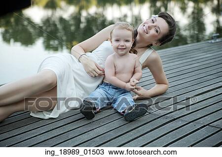 Stock Image - Brunette young mother posing with her son. Fotosearch