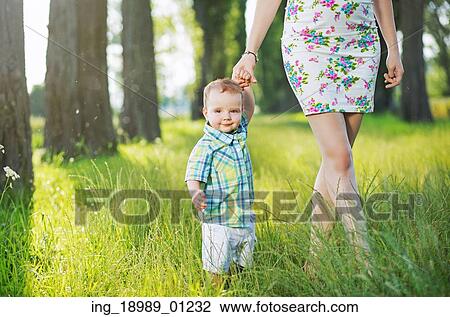 Stock Image - Cheerful child holding mom&rsquo; s hand. Fotosearch