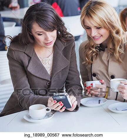 Cheerful ladies playing the mobile phone View Large Photo Image Stock Photo - Cheerful ladies playing the mobile phone. Fotosearch