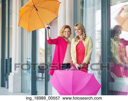 Cheerful ladies posing with the colorful umbrellas View Large Photo Image Stock Photo - Cheerful ladies posing with the colorful umbrellas. Fotosearch
