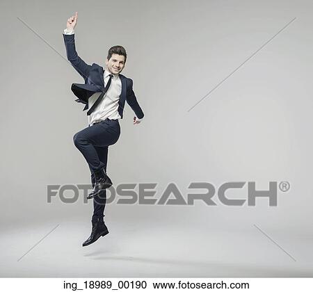 Stock Image - Cheerful young businessman achieving the succes. Fotosearch