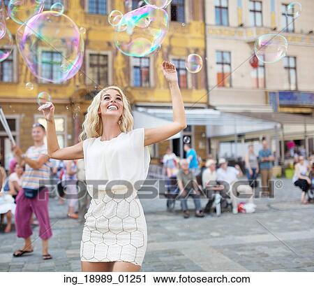 Cheerful young lady catching the soap bubbles View Large Photo Image Stock Image - Cheerful young lady catching the soap bubbles. Fotosearch