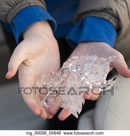 Stock Photograph - Close-up of hands holding pieces of ice, Lake Of The Woods, Ontario, Canada. Fotosearch