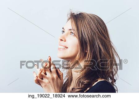 Picture - Closeup portrait of a young woman praying. Fotosearch