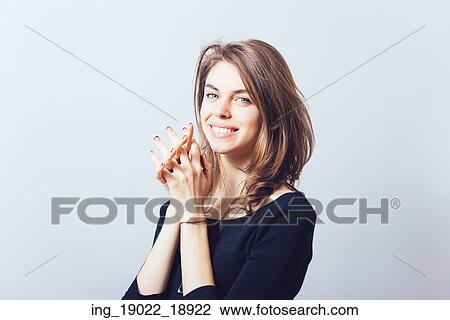 Stock Image - Closeup portrait of a young woman praying. Fotosearch