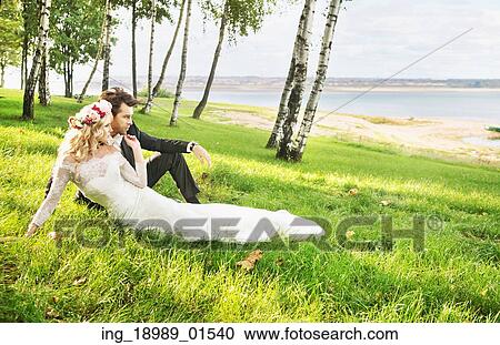 Stock Image - Couple spending their honeymoon by the lakeside. Fotosearch