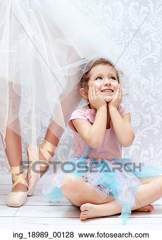 Stock Photo - Cute girl next to the ballet dancer sister. Fotosearch