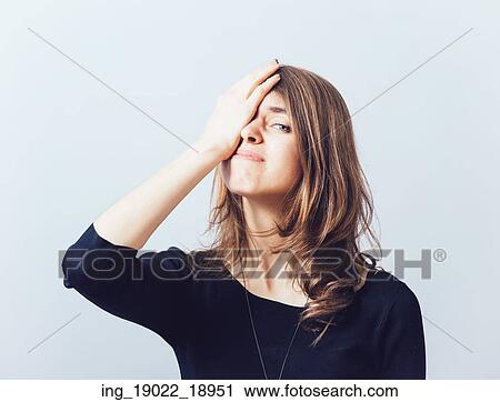 Stock Image - Cute girl remembered something and holding his head. Fotosearch