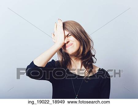 Stock Photo - Cute girl remembered something and holding his head. Fotosearch
