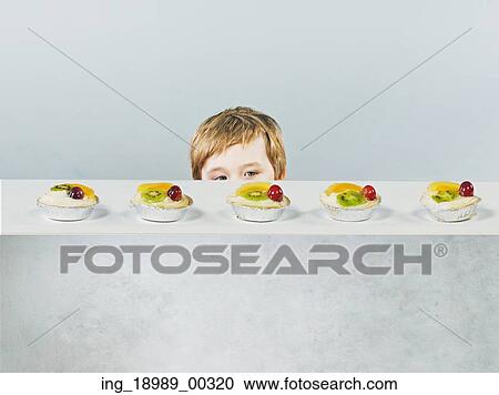 Cute little boy with delicious fruit cake View Large Photo Image Stock Image - Cute little boy with delicious fruit cake. Fotosearch
