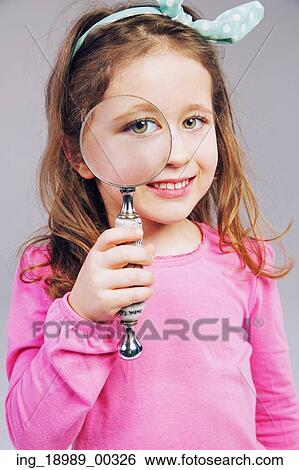 Stock Photograph - Cute little girl looking through a magnifying glass. Fotosearch