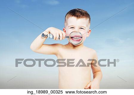 Stock Photography - Cutel little boy looking through a magnifying glass. Fotosearch