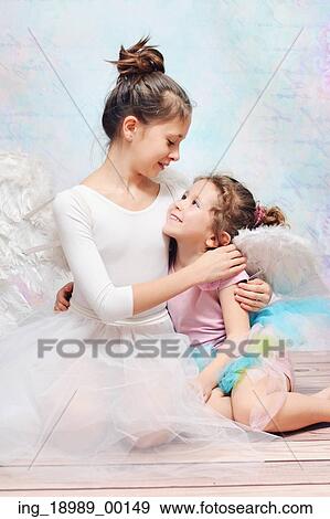 Stock Photo - Elder ballet dancer hugging her little cute sister. Fotosearch