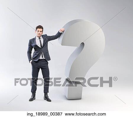 Stock Photo - Elegant young man leaning against the huge question mark. Fotosearch