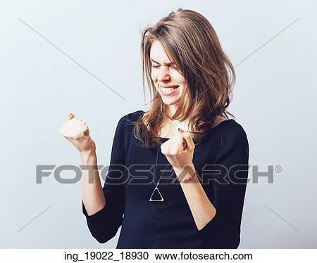 Excited young woman with fists up View Large Photo Image Stock Image - Excited young woman with fists up. Fotosearch