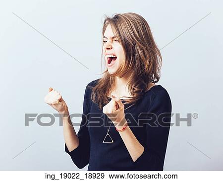Stock Photo - Excited young woman with fists up. Fotosearch