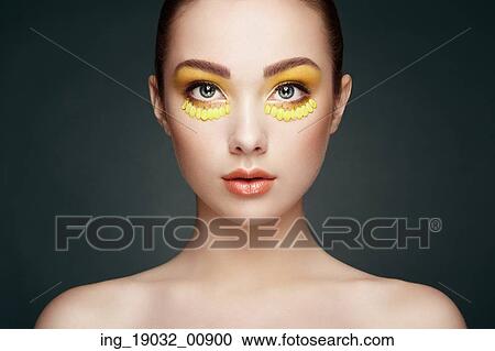 Stock Image - Face of beautiful woman decorated with flowers. Perfect makeup. Beauty fashion. Eyelashes. Cosmetic Eyeshadow. Fotosearch
