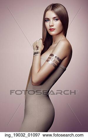 Fashion portrait of elegant woman with magnificent hair. blonde girl. Perfect make-up. Girl in elegant dress. Flash tattoo gold View Large Photo Image Stock Photo - Fashion portrait of elegant woman with magnificent hair. blonde girl. Perfect make-up. Girl in elegant dress. Flash tattoo gold. Fotosearch