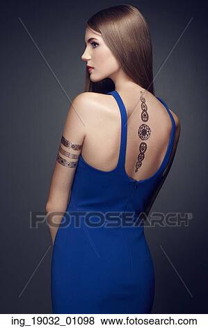Stock Photo - Fashion portrait of elegant woman with magnificent hair. blonde girl. Perfect make-up. Girl in elegant dress. Flash tattoo gold. Fotosearch