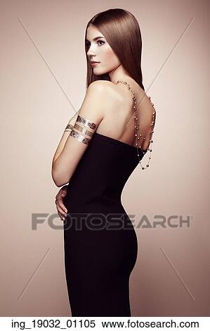 Stock Photography - Fashion portrait of elegant woman with magnificent hair. Blonde girl. Perfect make-up. Girl in elegant dress. Flash tattoo gold. Fotosearch