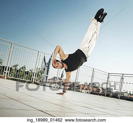 Stock Image - Fit man doing push-ups with one hand. Fotosearch
