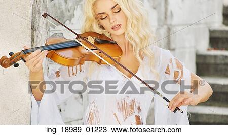 Stock Image - Focused lady playing the violin. Fotosearch