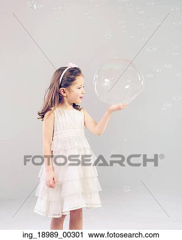Funny lovely little woman playing with soap bubbles View Large Photo Image Stock Image - Funny lovely little woman playing with soap bubbles. Fotosearch