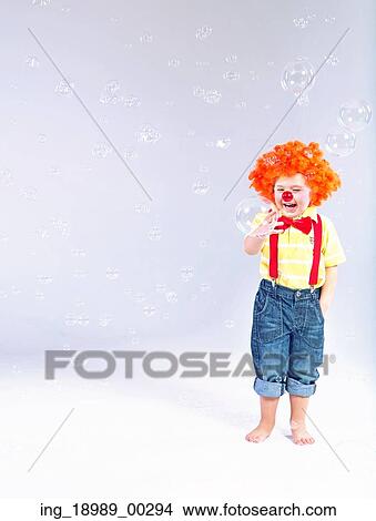 Picture - Funny picture of little clown making large soap bubbles. Fotosearch