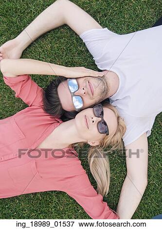 Stock Photo - Funny picture of the lying couple with sunglasses. Fotosearch